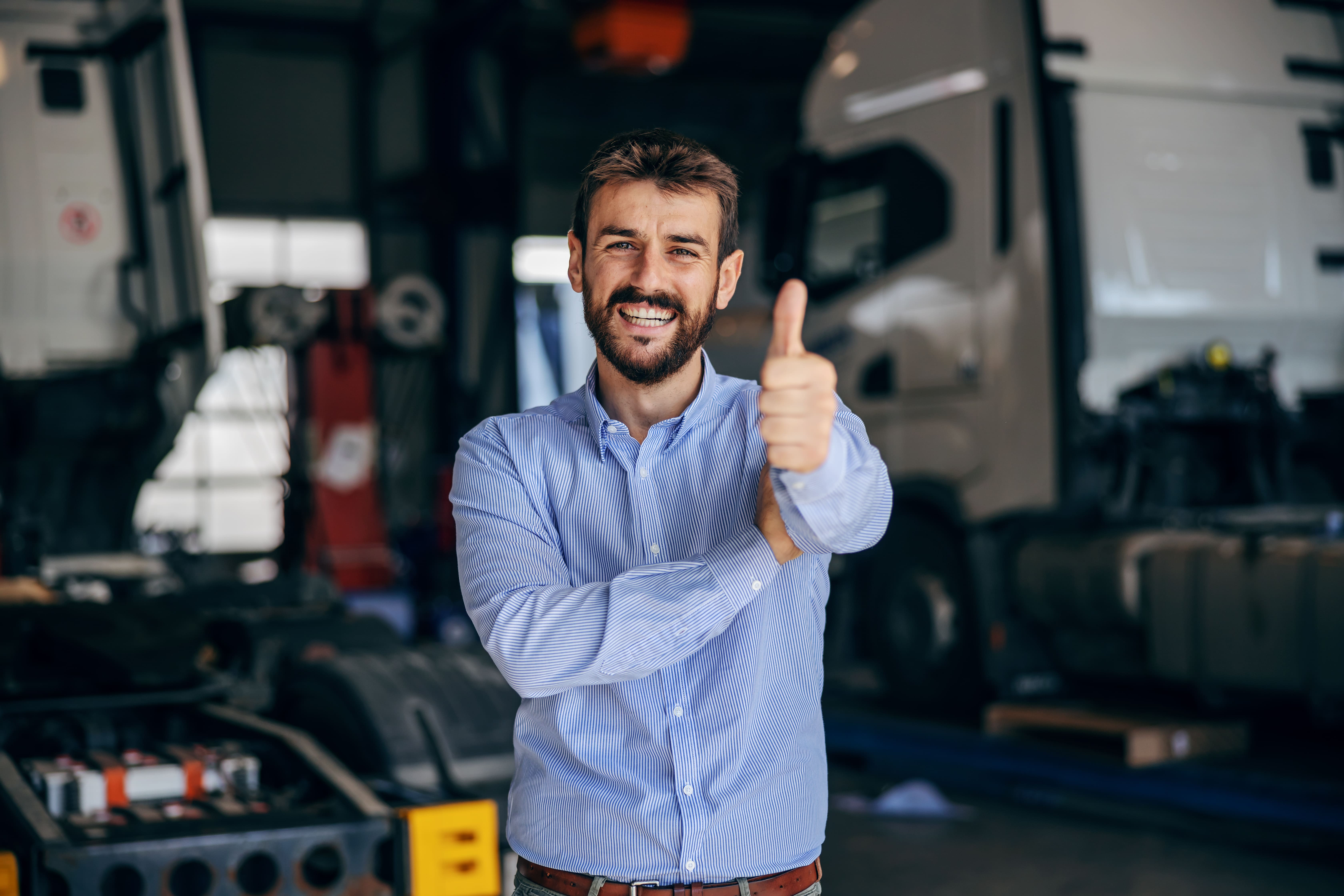 smiling chief standing auto park showing thumbs up firm from import export